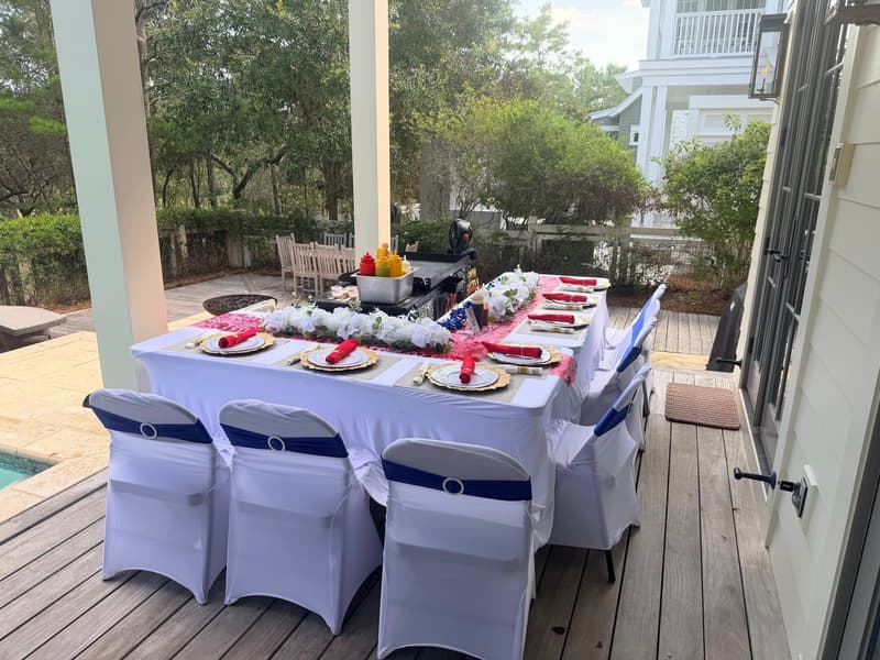 Table set for twelve on a covered porch beside the pool, the hibachi grill standing at the head of the table